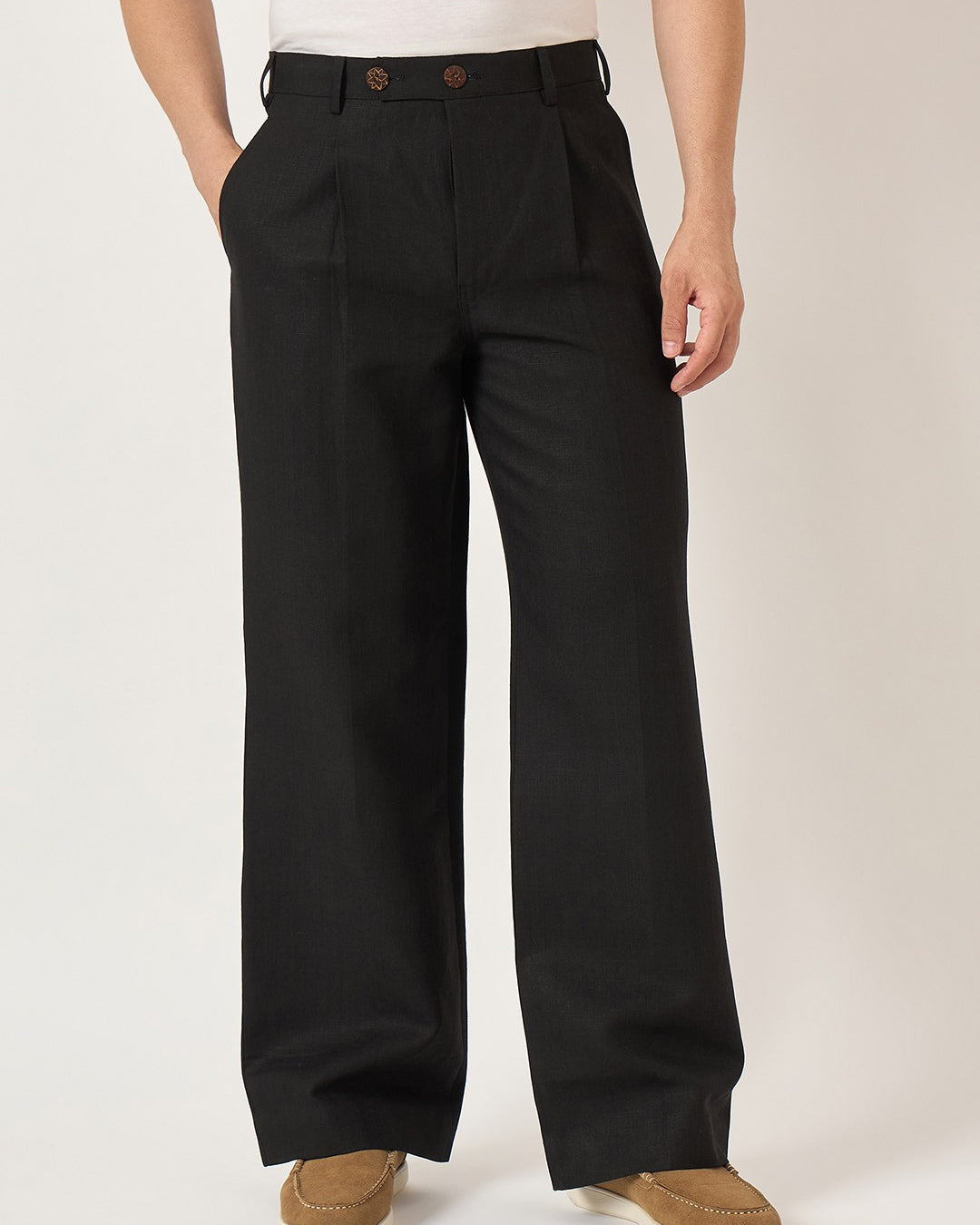 Person wearing black wide-leg pants on a plain background