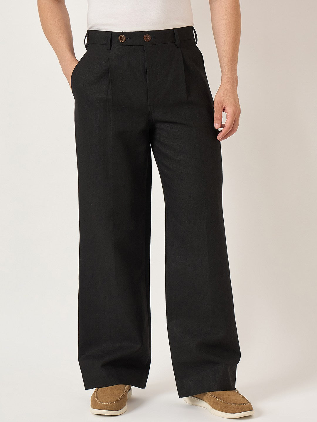 Person wearing black wide-leg pants on a plain background