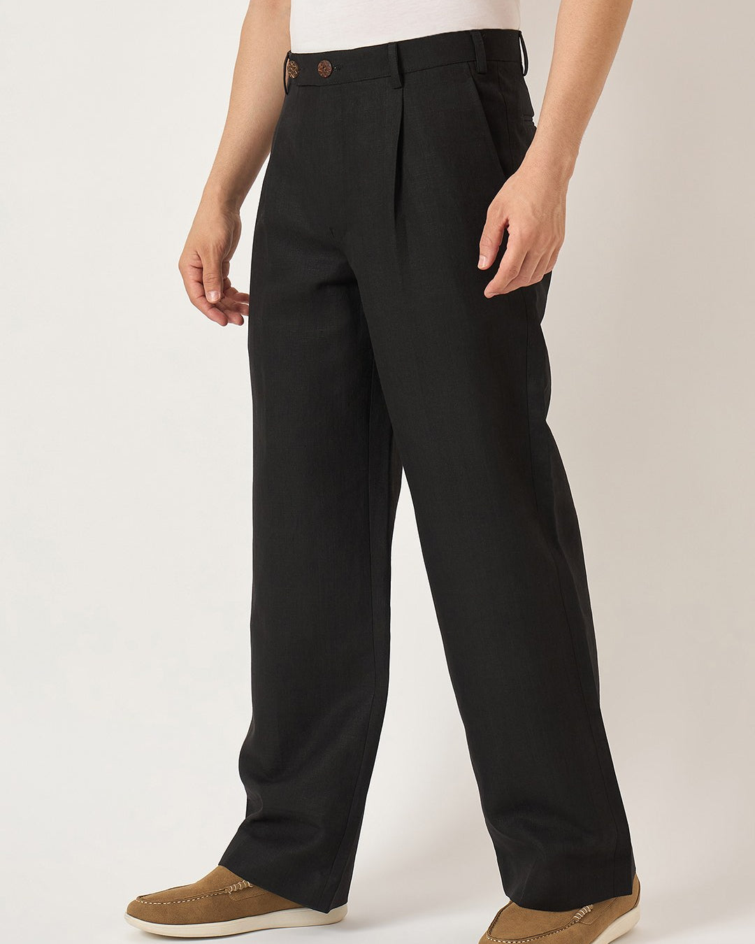 Person wearing black pants on a plain background