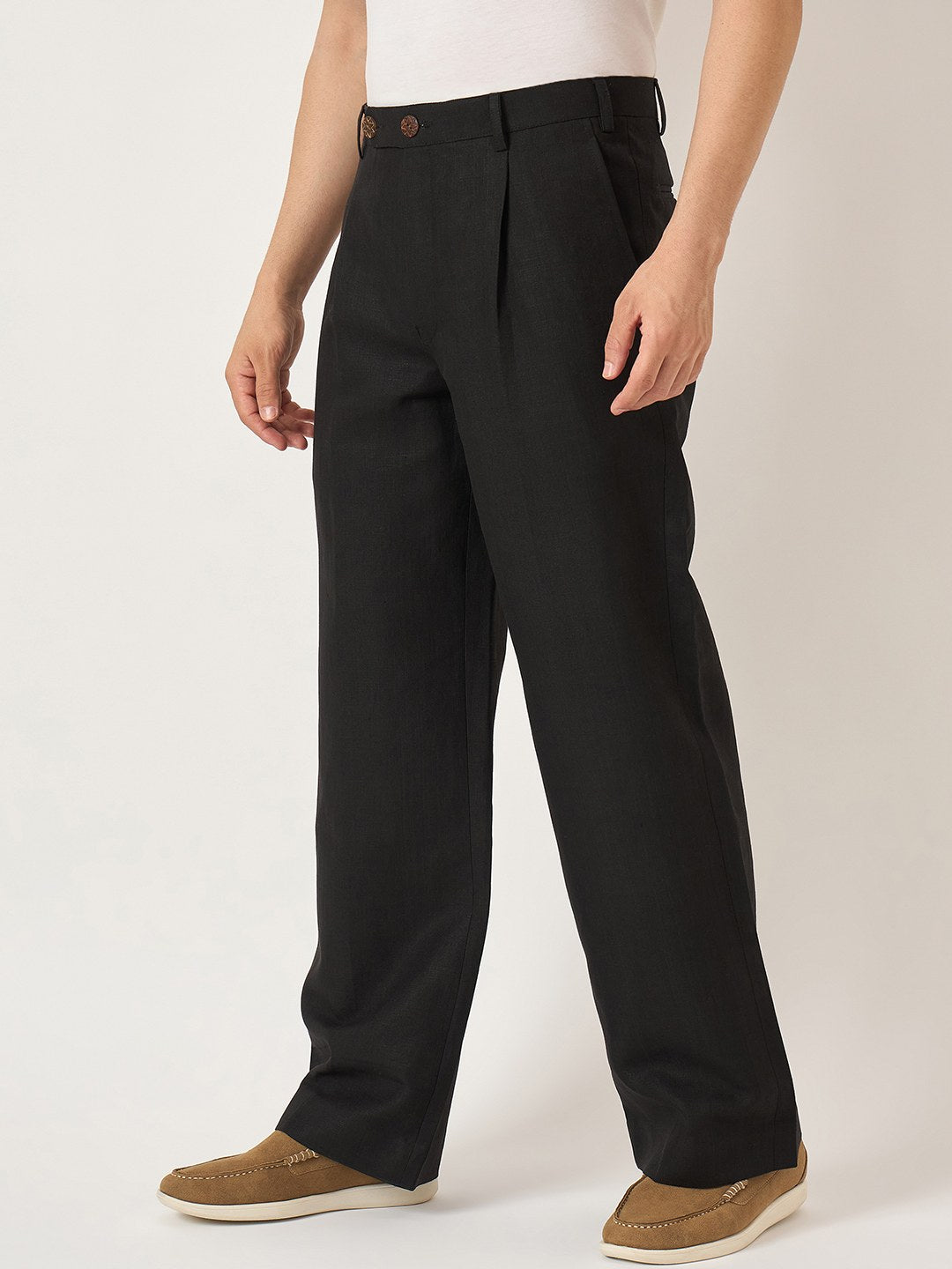 Person wearing black pants on a plain background