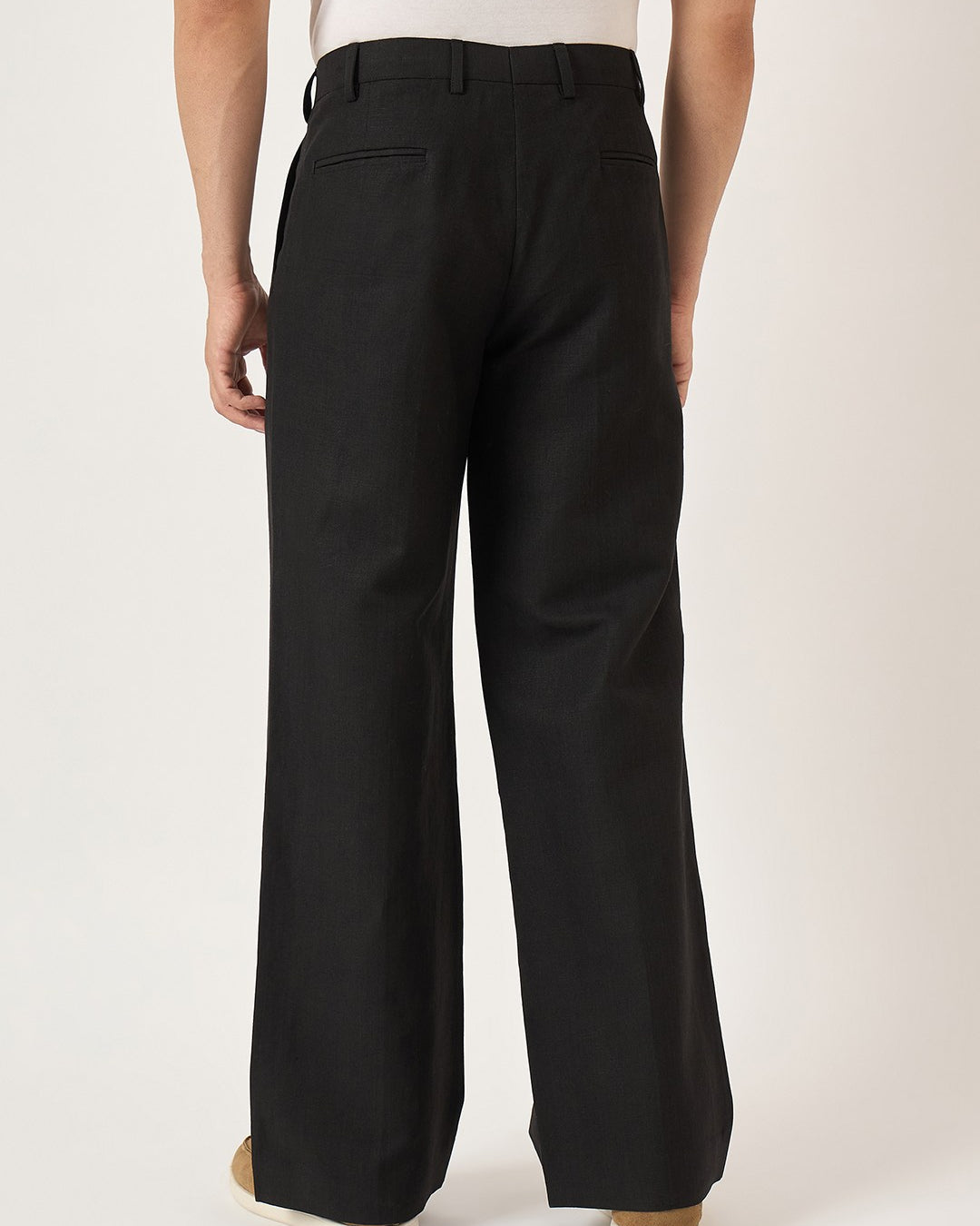 Black pants worn by a person on a white background