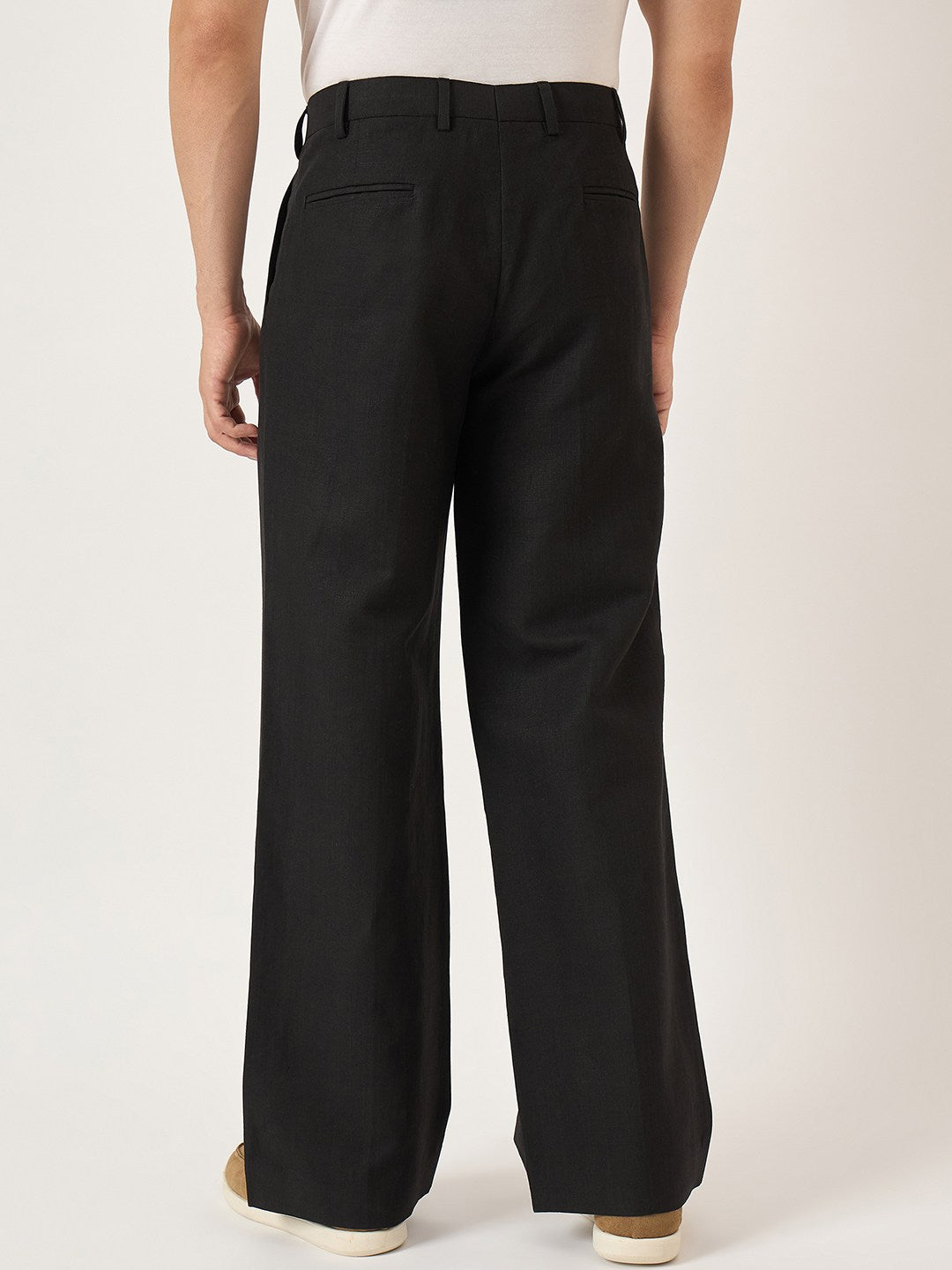Black pants worn by a person on a white background