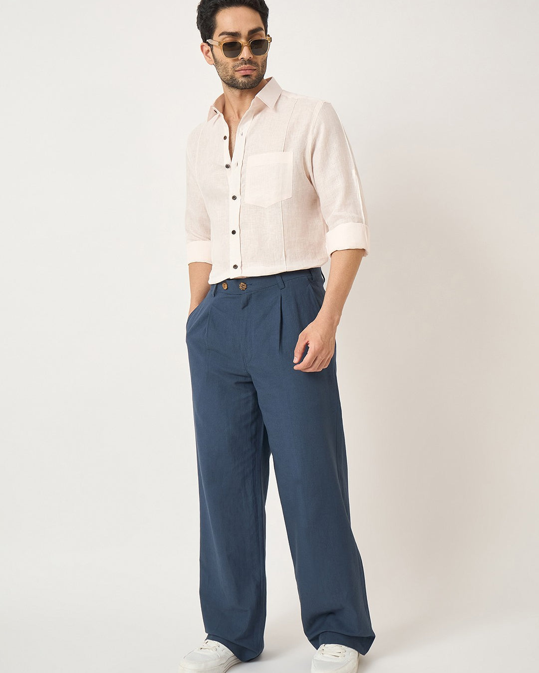 Man wearing a white shirt and blue pants on a white background