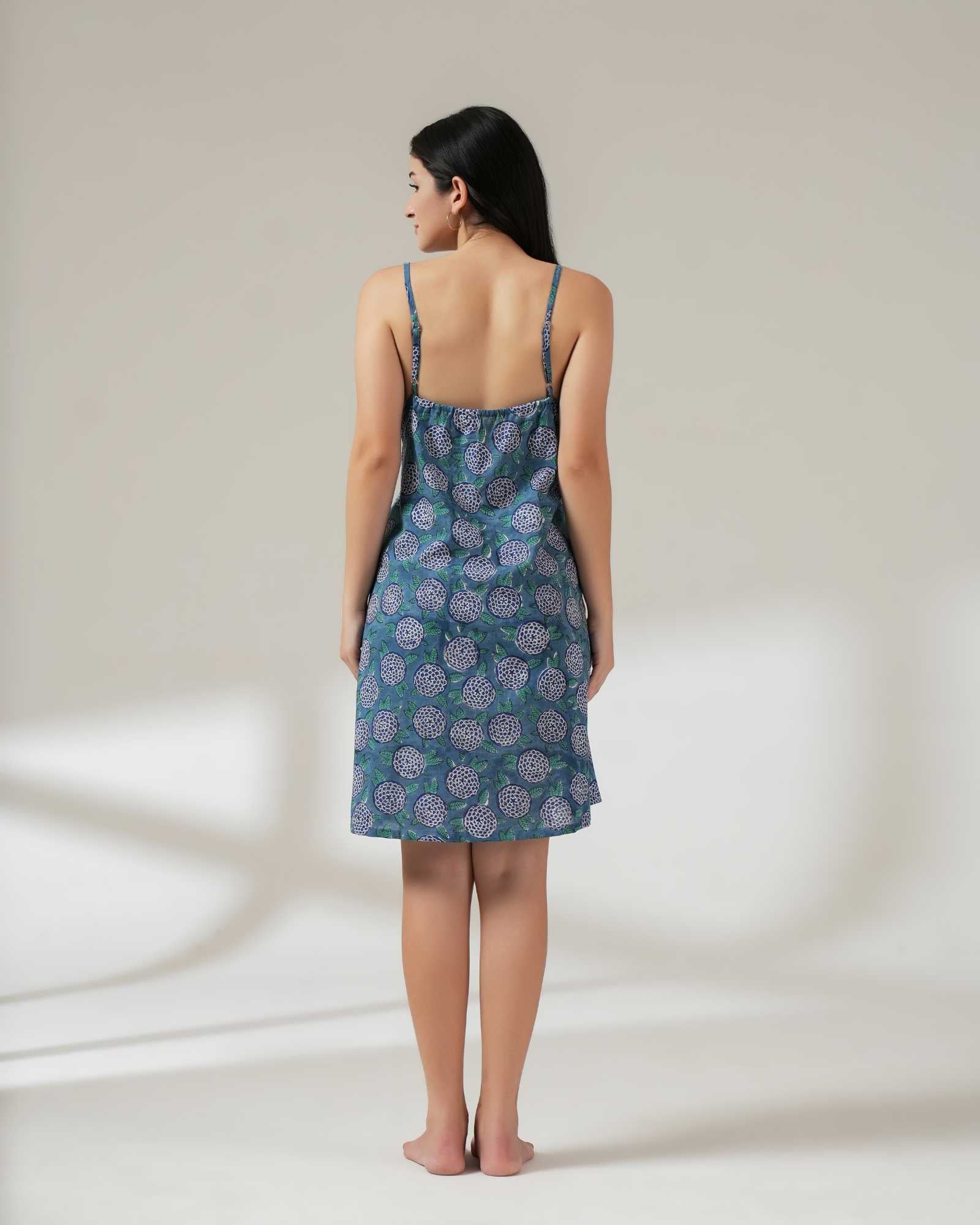 Woman wearing a blue patterned nightgown against a white background