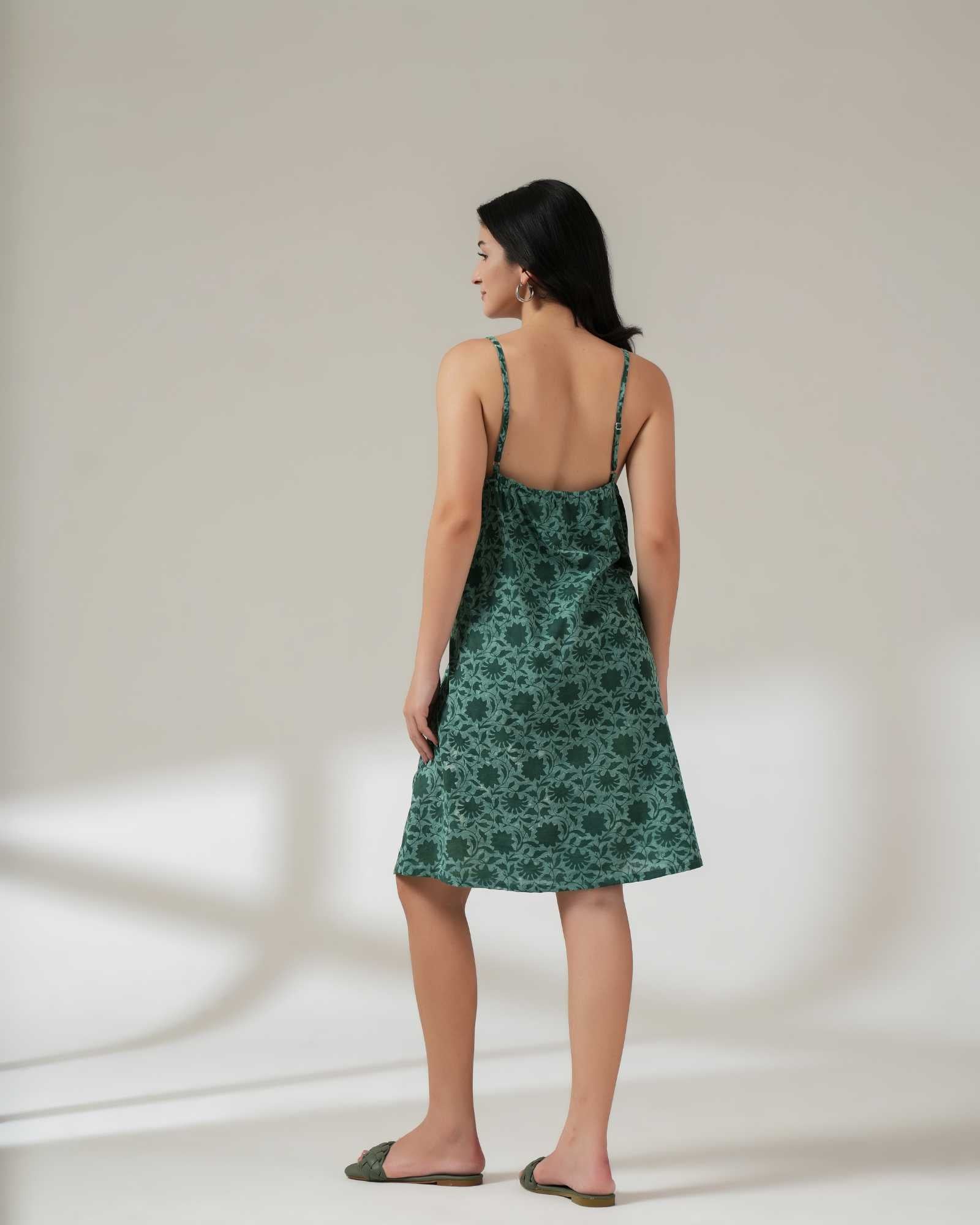 Woman wearing a green floral dress against a neutral background