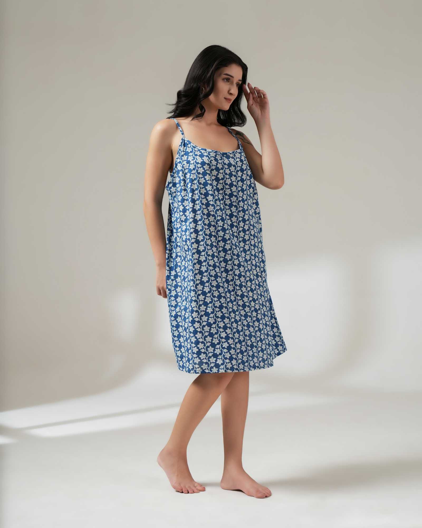 Woman wearing a blue floral nightgown against a plain background