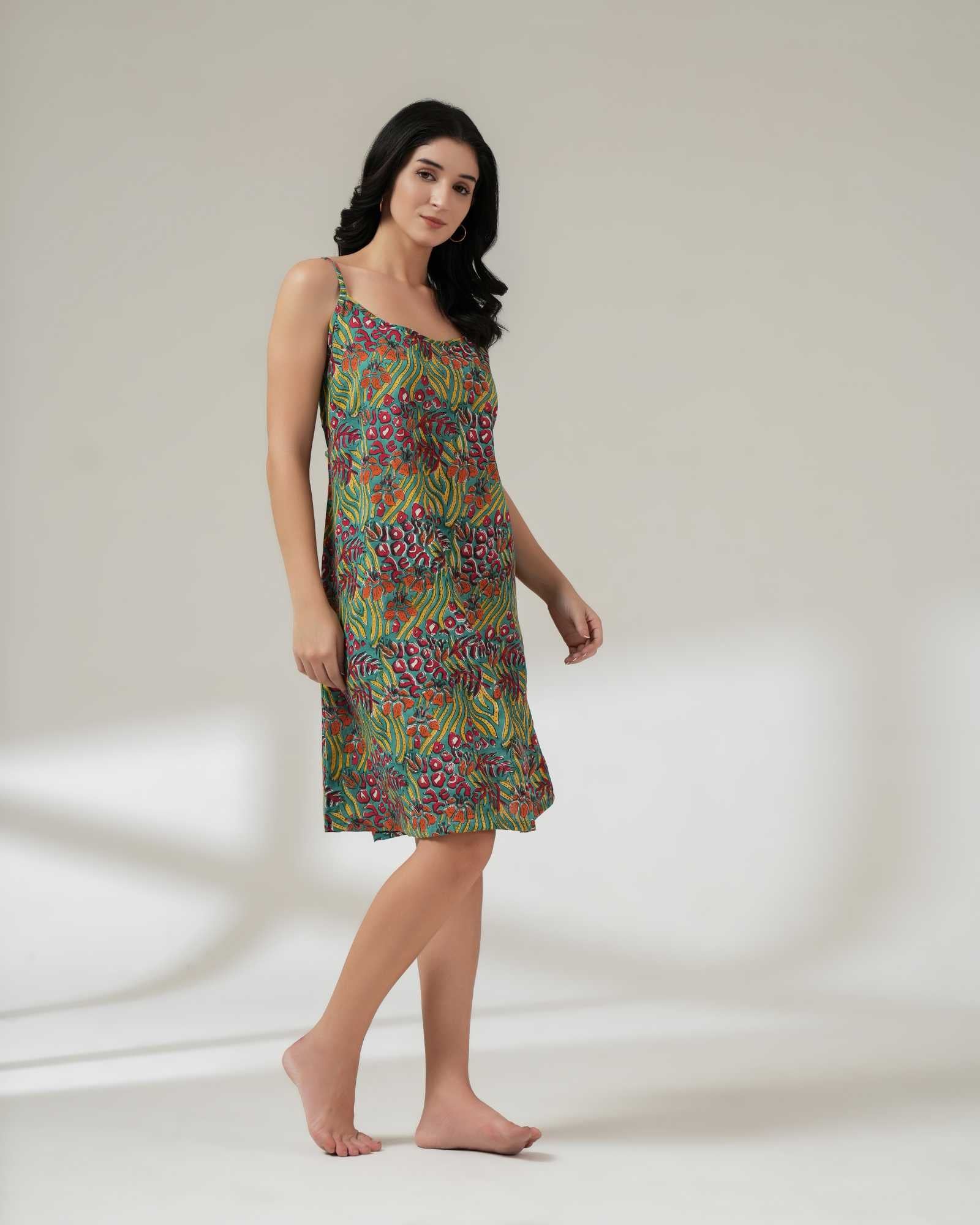 Woman wearing a colorful patterned dress on a plain background
