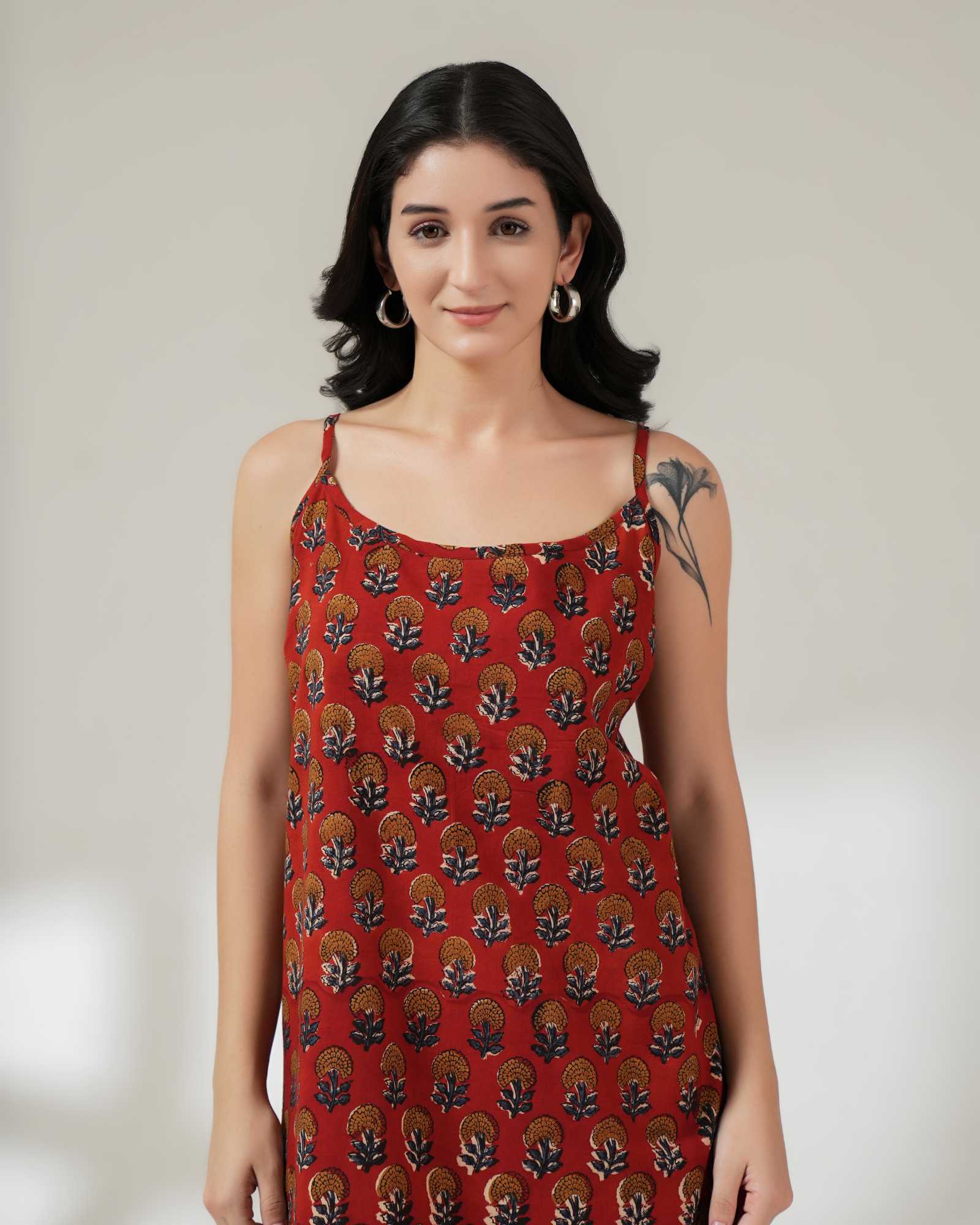 Woman wearing a red patterned dress against a plain background