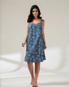 Woman wearing a blue patterned dress on a white background
