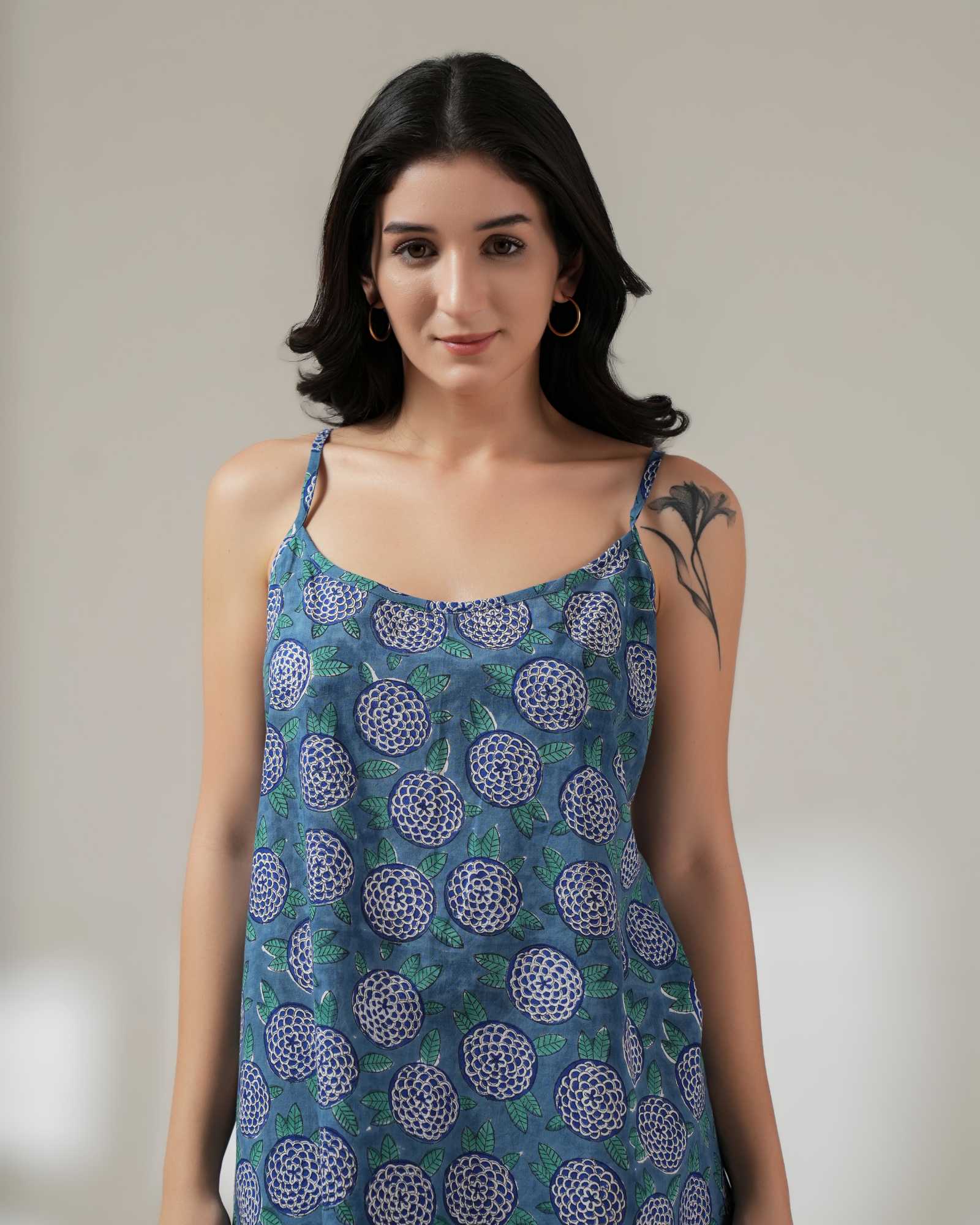 Woman wearing a blue patterned dress against a plain background