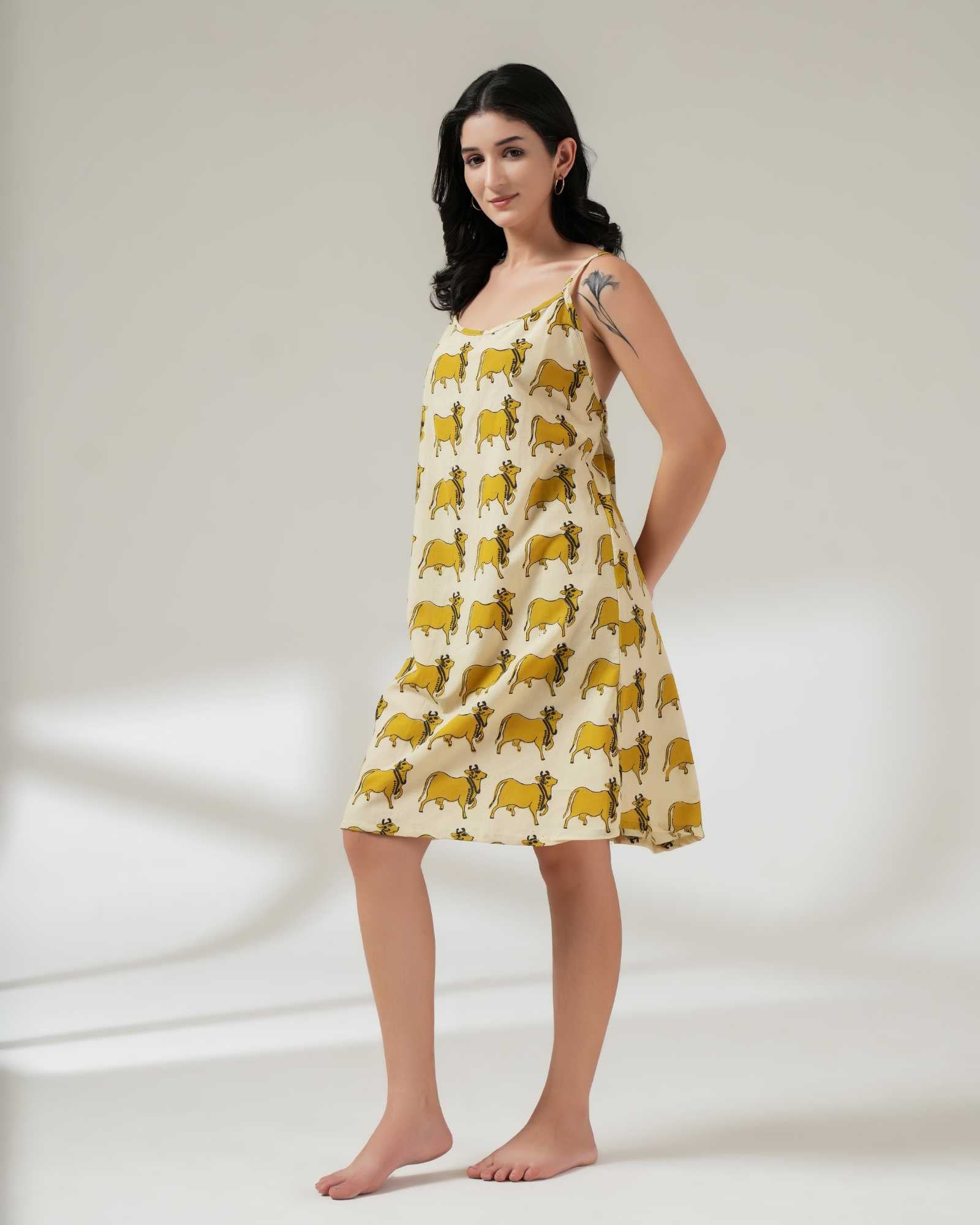 Woman wearing a yellow patterned dress on a white background