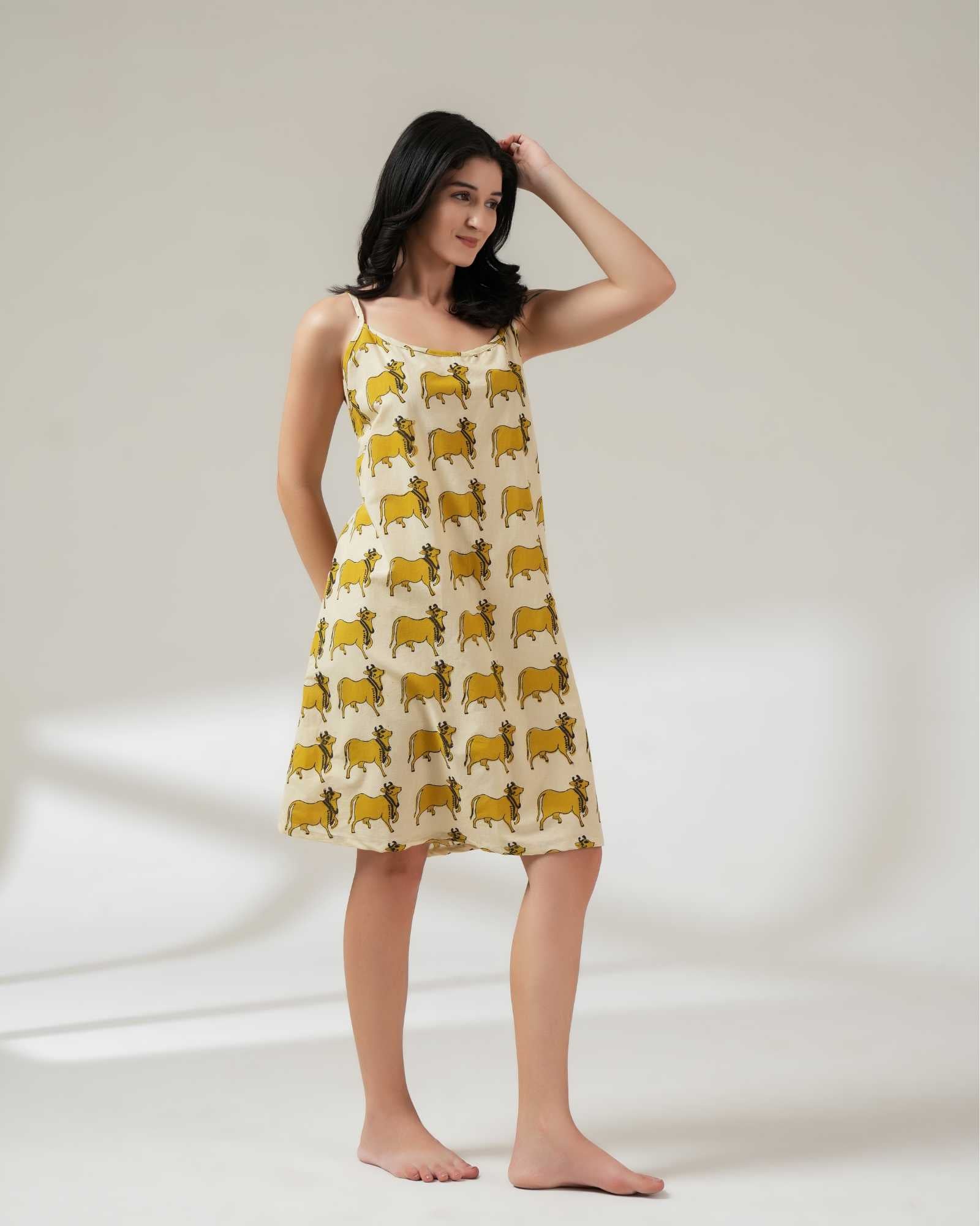 Woman wearing a yellow patterned dress on a white background