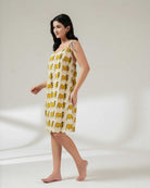 Woman wearing a yellow patterned dress on a white background