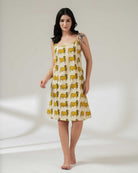 Woman wearing a sleeveless dress with yellow pattern on a white background
