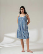 Woman wearing a blue floral dress on a plain background