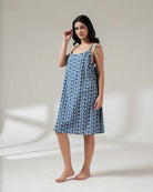 Woman wearing a blue floral dress against a white background