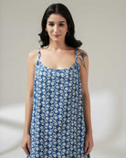 Woman wearing a blue floral dress against a plain background