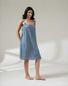 Woman wearing a blue floral dress on a plain background