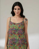 Woman wearing a colorful patterned dress against a plain background