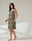 Woman wearing a colorful patterned dress on a plain background