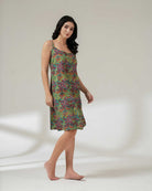 Woman wearing a colorful patterned dress on a plain background