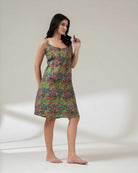 Woman wearing a colorful patterned dress on a plain background