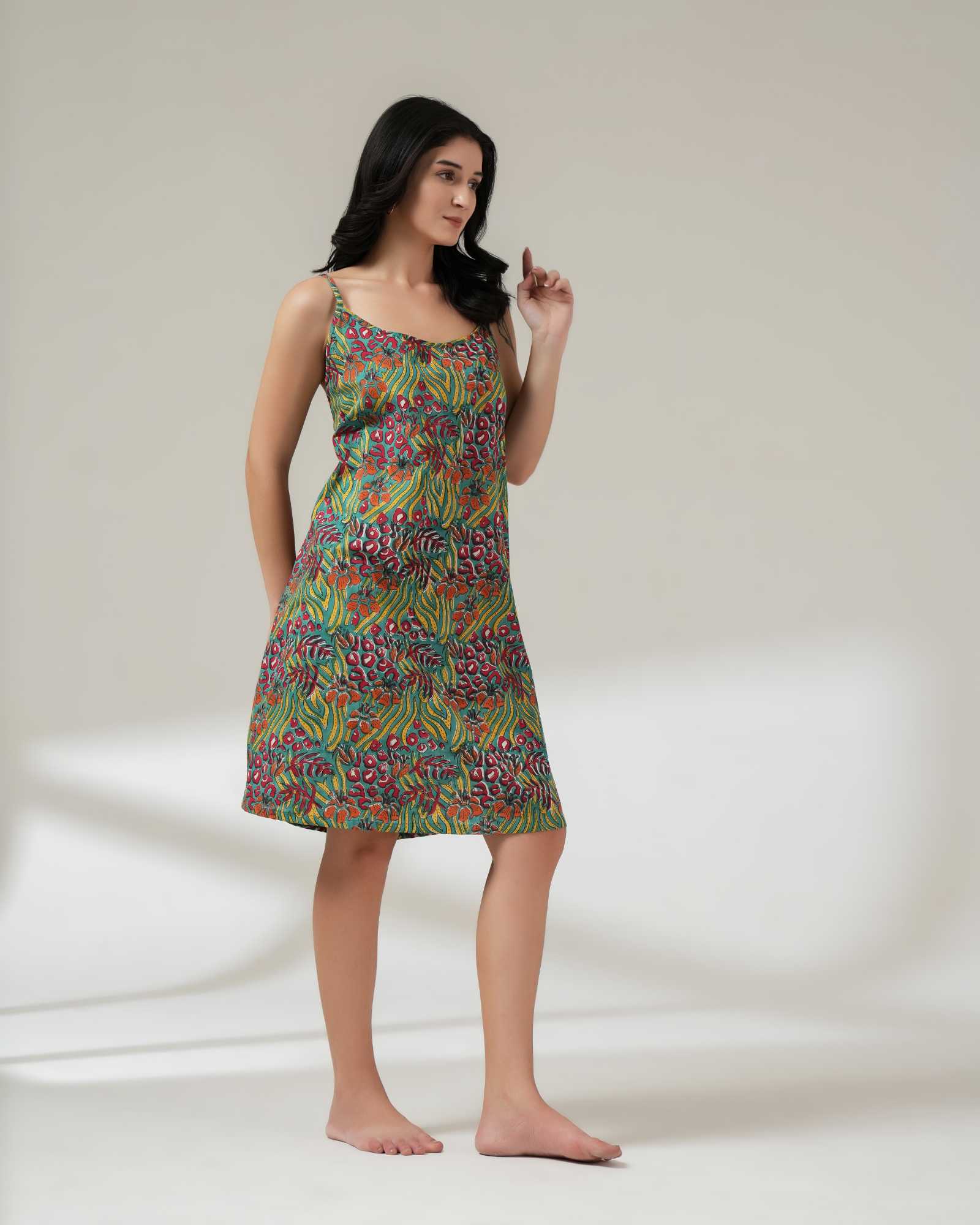 Woman wearing a colorful patterned dress on a plain background