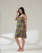 Woman wearing a colorful patterned dress on a plain background
