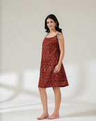 Woman wearing a red patterned dress against a white background