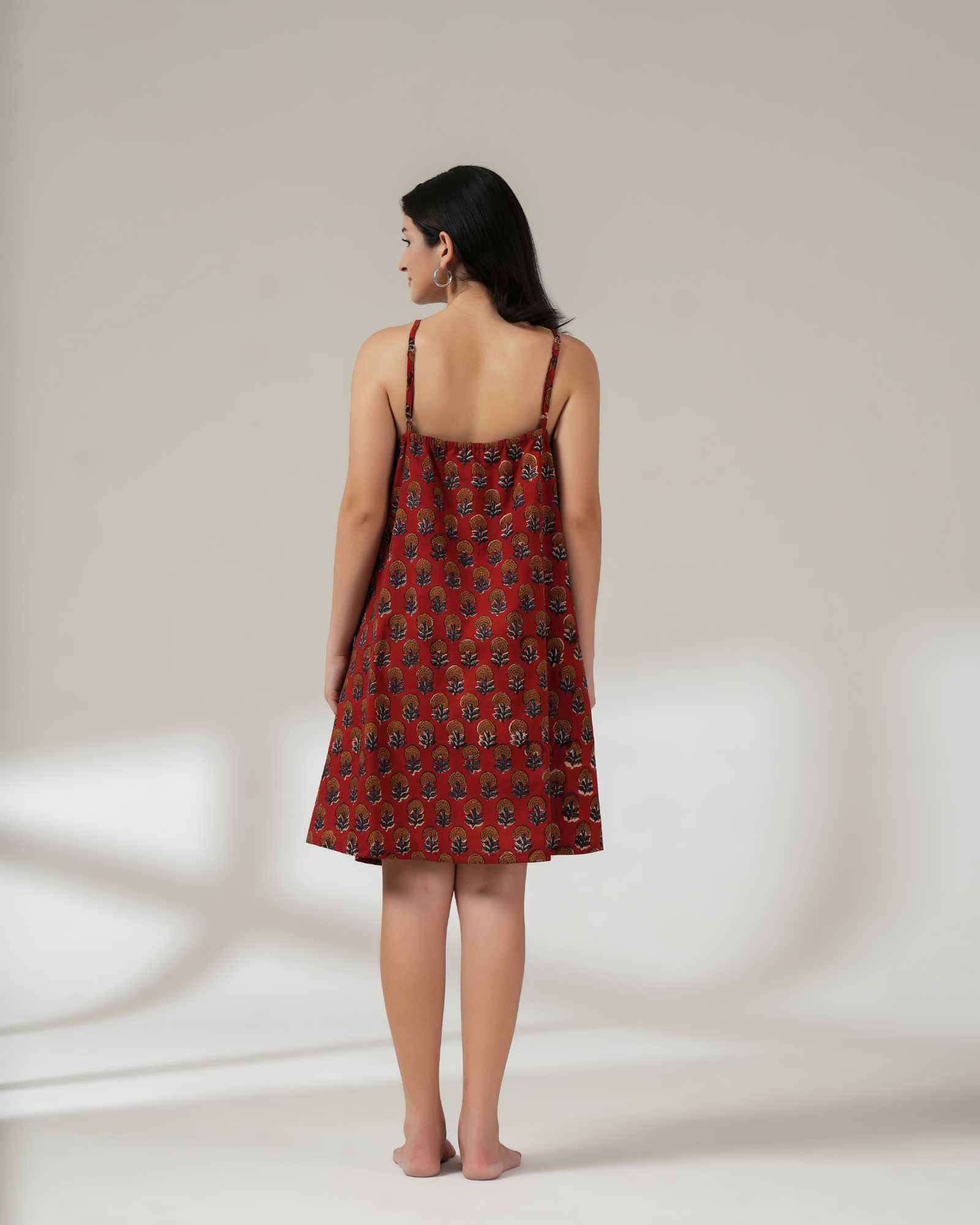 Woman wearing a red patterned dress against a white background