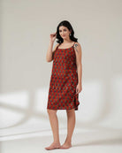 Woman wearing a red patterned dress on a white background