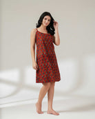 Woman wearing a red patterned dress on a white background