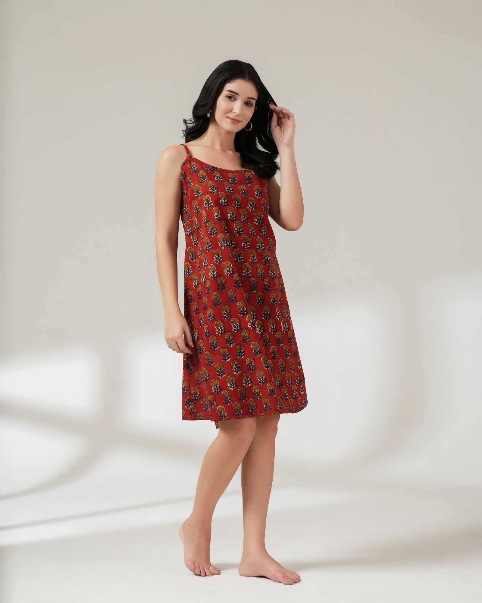 Woman wearing a red patterned dress on a white background