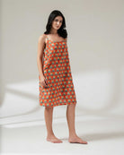 Woman wearing a patterned dress on a plain background