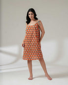 Woman wearing a patterned dress on a plain background