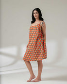 Woman wearing a patterned dress on a plain background