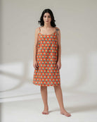 Woman wearing a patterned dress on a plain background