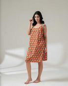 Woman wearing a patterned dress on a plain background