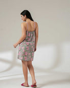 Woman wearing a floral nightgown against a plain background