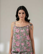 Woman wearing a floral top with a plain background